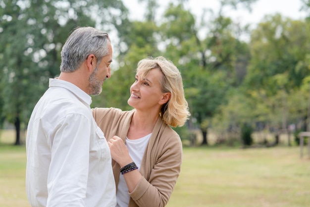 Casal feliz sênior olhando um ao outro enquanto caminhava no parque