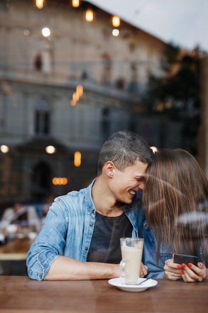 Casal feliz sentado à mesa em uma cafeteria
