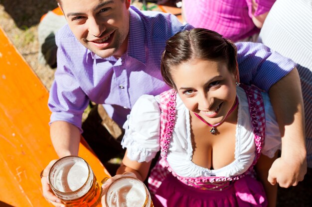 Foto casal feliz sentado no jardim da cerveja