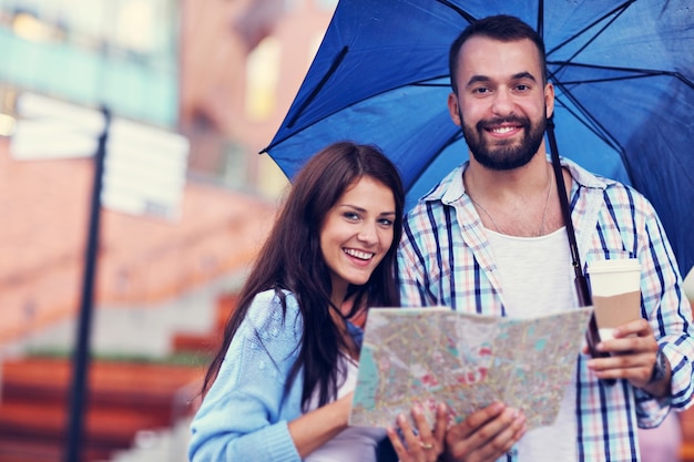 Casal feliz sob o guarda-chuva na cidade