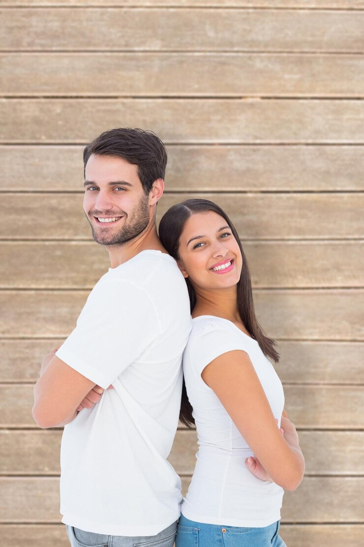 Foto casal feliz sorrindo para a câmera contra pranchas de madeira
