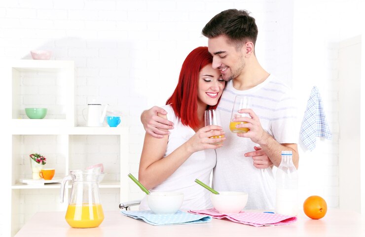 Foto casal feliz toma café da manhã na cozinha