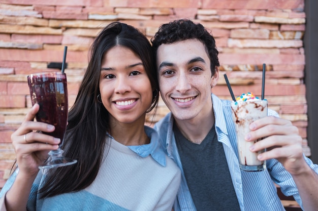 Casal feliz tomando um copo de bebidas no bar.