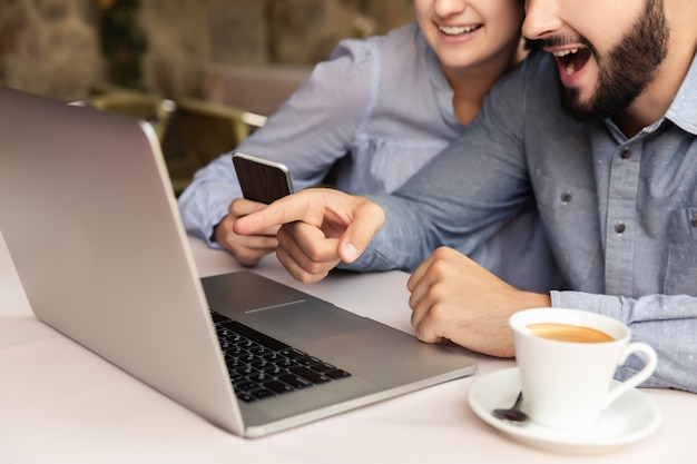 Casal feliz trabalhando em casa, homem e mulher trabalhando no laptop dentro de casa