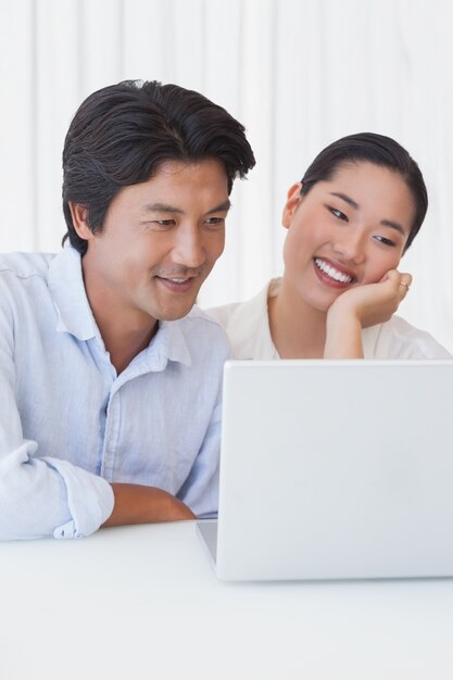 Casal feliz usando laptop juntos