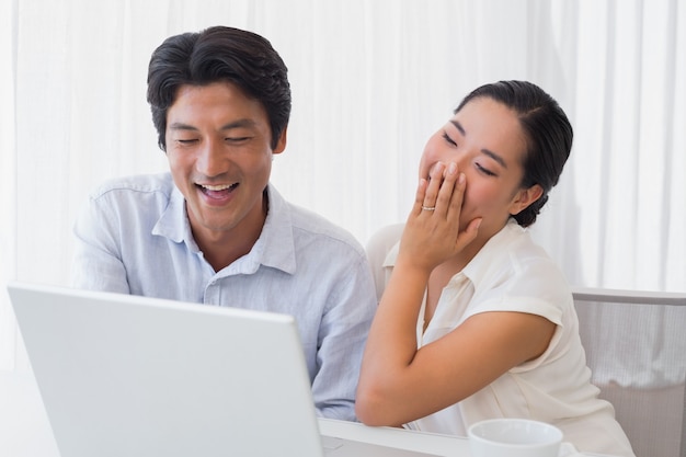 Casal feliz usando laptop juntos