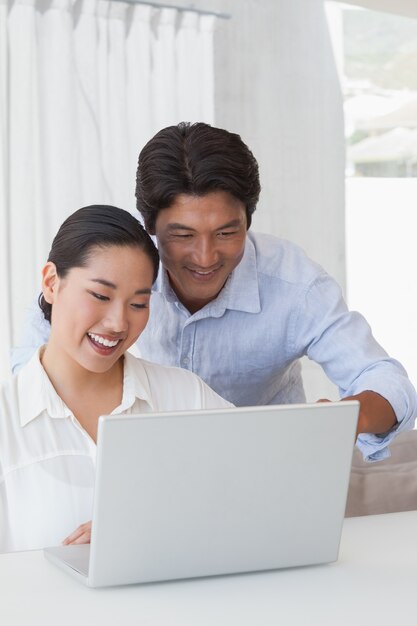 Casal feliz usando laptop juntos