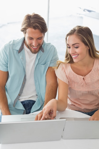 Casal feliz usando seus laptops