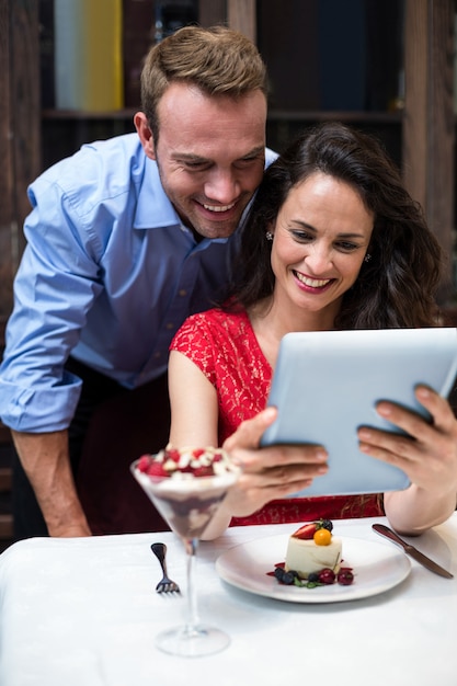 Casal feliz usando tablet digital