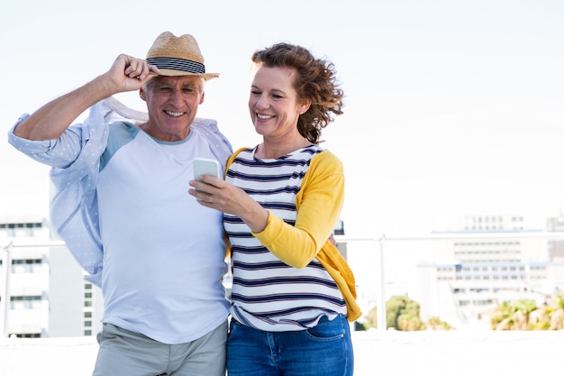 Casal feliz usando telefone celular na cidade