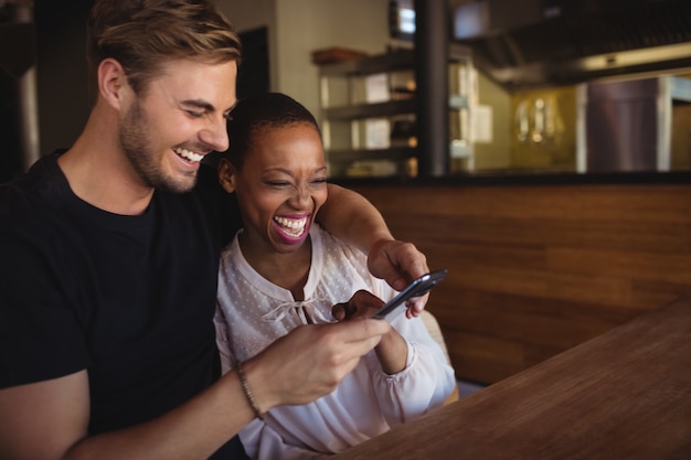 Casal feliz usando telefone celular