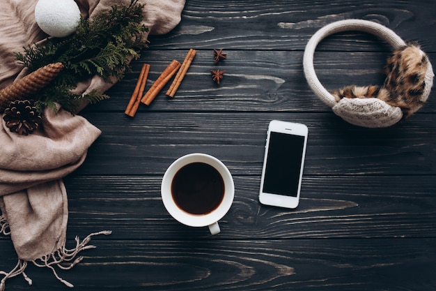 Casal feminino com copo de café. Decoração e comida de Natal em fundo de madeira.