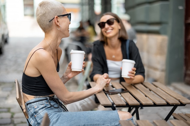 Casal feminino elegante na esplanada do café ao ar livre