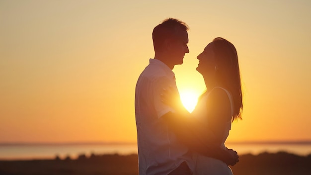 Casal fica mostrando puro amor um ao outro ao pôr do sol