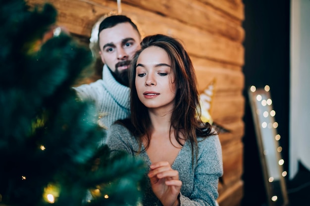 Casal focado decorando a árvore de Natal