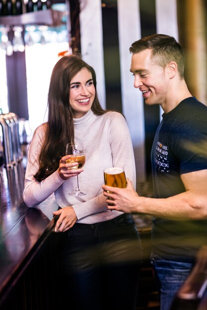 Casal fofo conversando e tomando uma bebida em um bar