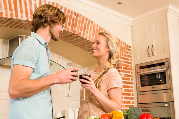 Casal fofo, desfrutando de um copo de vinho na cozinha