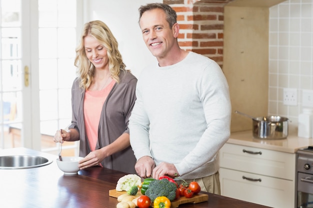 Casal fofo fatiar legumes na cozinha