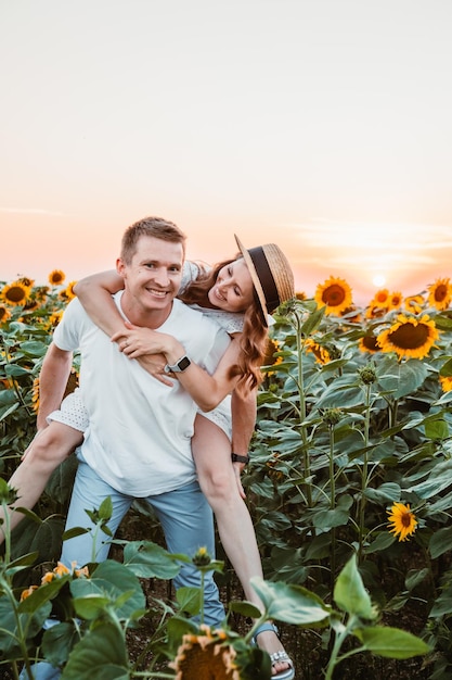 Casal fofo no campo de girassóis no espaço de cópia do pôr do sol