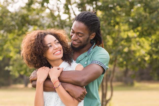 Foto casal fofo no parque fazendo formato de coração