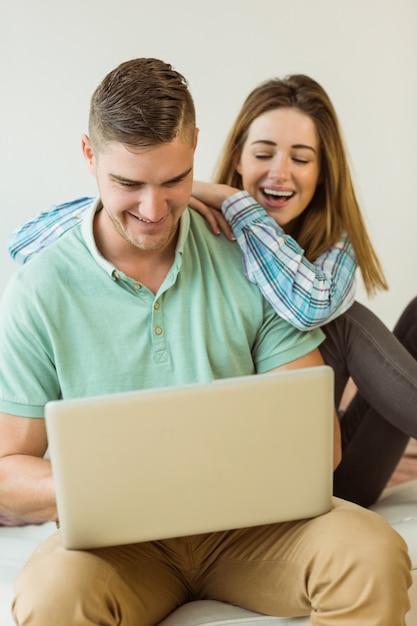 Casal fofo relaxando no sofá com o laptop