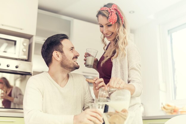 Casal fofo tomando café da manhã em casa na cozinha