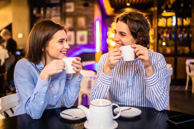 Casal fofo tomando café ou chá juntos no café