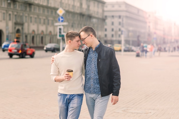 Casal gay caminhando no centro de uma cidade, estilo de vida