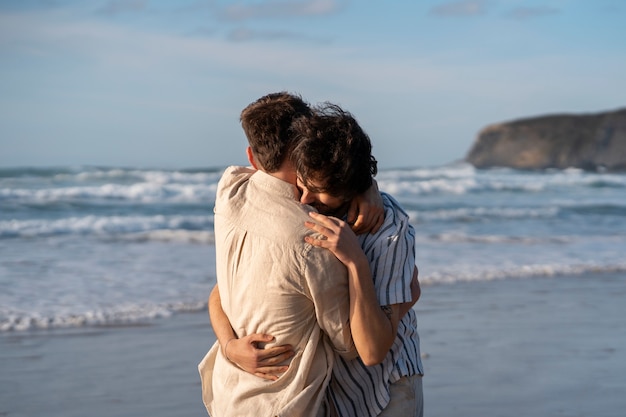 Foto casal gay de tiro médio na praia