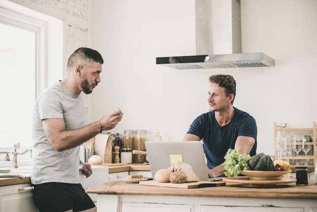 Casal gay masculino seriamente falando em casa de manhã