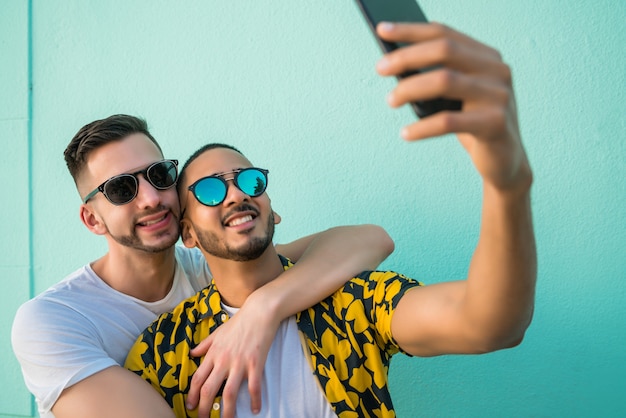 Casal gay tomando uma selfie com telefone móvel.