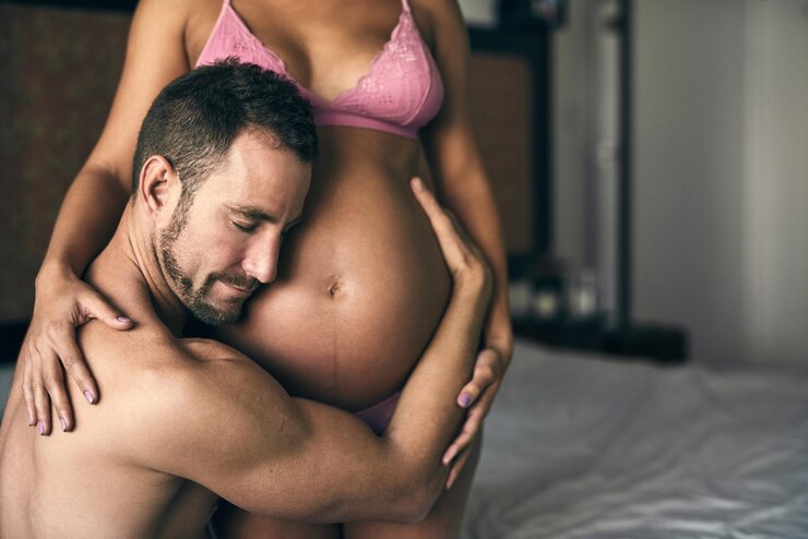 Foto casal grávida e ouvindo o estômago no quarto para se ligar com o amor do bebê e sentir chutar pessoas de apoio materno e entusiasmado para a paternidade em casa com roupa interior batimento cardíaco e abraçar a mãe