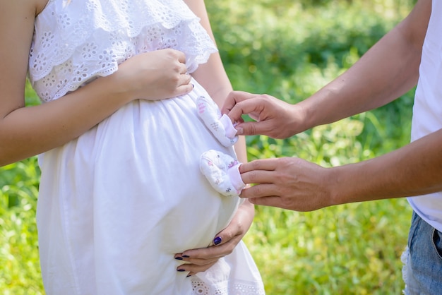 Casal grávida segurando o bebê mostra perto da barriga