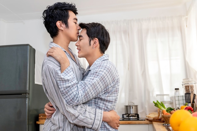 Casal homossexual asiático abraço e beijo na cozinha pela manhã. Conceito LGBT gay.