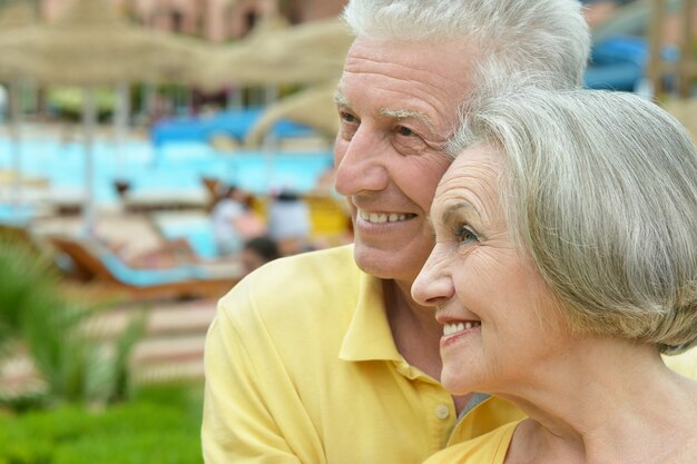 Casal idoso bebendo suco na piscina de um resort de hotel