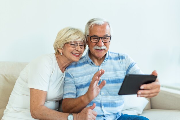 Casal idoso usando tablet digital em casa