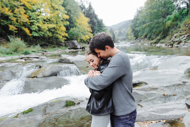 casal incrivelmente bonito e adorável perto de um rio de montanha