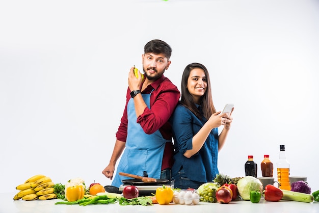 Casal indiano na cozinha - Jovem linda esposa asiática gostando de cozinhar com o marido muitos vegetais frescos e frutas