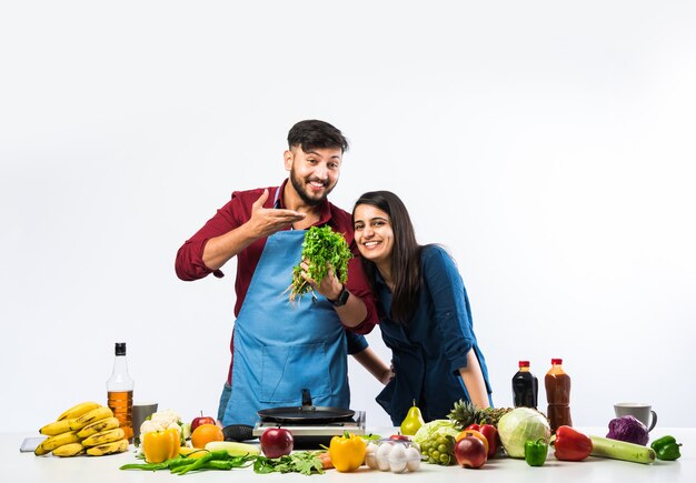 Casal indiano na cozinha - Jovem linda esposa asiática gostando de cozinhar com o marido muitos vegetais frescos e frutas