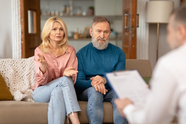 Casal infeliz consultando psicólogo profissional com crise de relacionamento dentro de casa