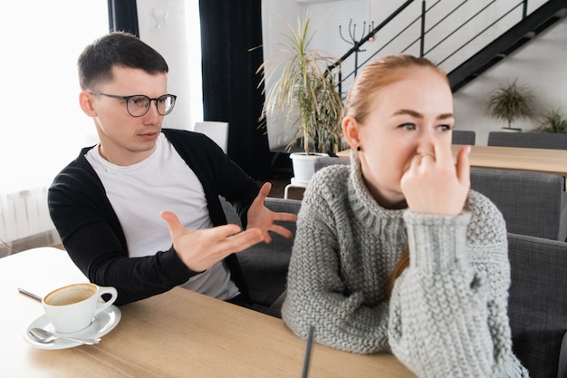 Casal infeliz tendo conflito no café