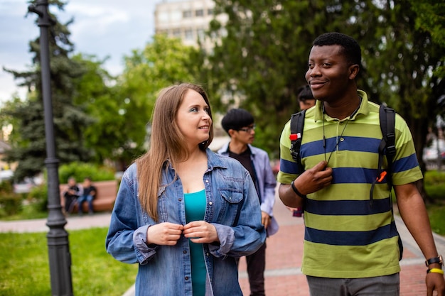 Casal interracial andando no parque junto com seus amigos