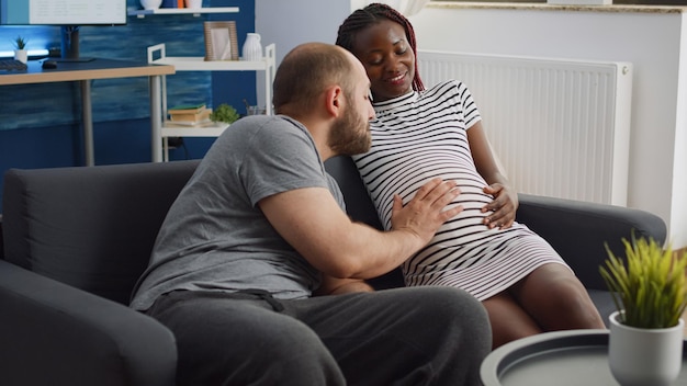 Casal interracial casado se unindo por causa de uma criança sentada em casa