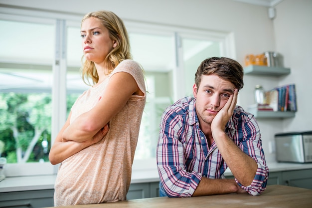 Casal irritado, ignorando o outro na cozinha