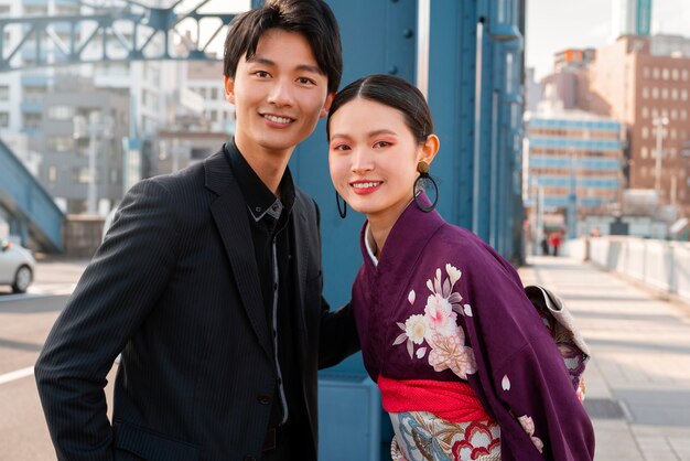 Foto casal japonês comemorando o dia da maioridade e posando juntos na cidade