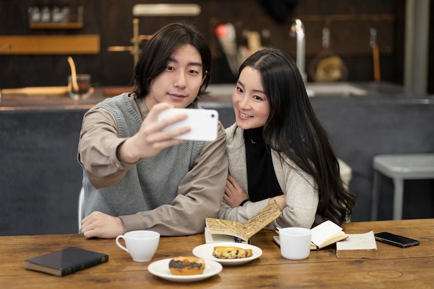 Casal japonês tomando selfie em um restaurante
