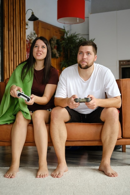 Casal jogando videogame no sofá