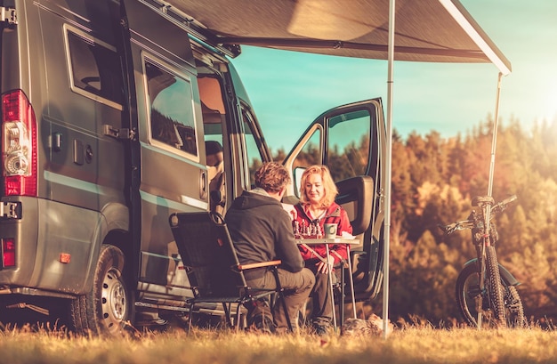 Foto casal jogando xadrez ao lado de sua caravana rv