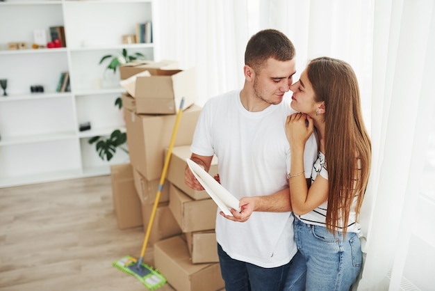 Casal jovem alegre em seu novo apartamento. Concepção de movimento.