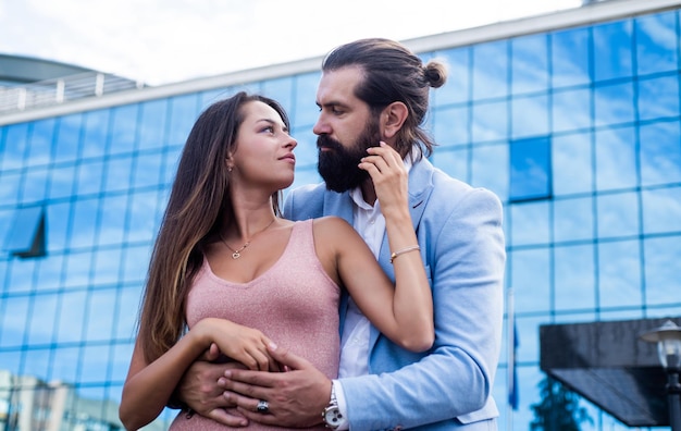 Casal jovem amoroso na moda abraçando-se na rua da cidade desfrutando de relações juntos amor e romance